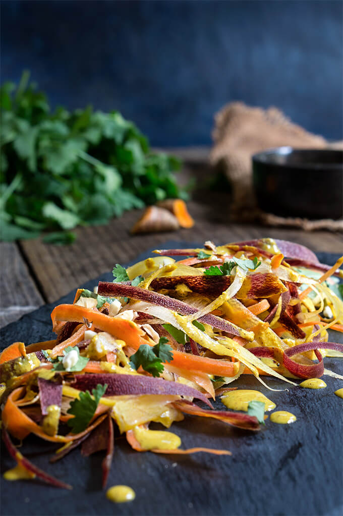 Carrot almond salad - ribbons of rainbow carrots, doused in creamy, turmeric coconut dressing, topped with toasted almonds and fresh cilantro - an explosion of exotic flavors that will surely tantalize your taste buds! | www.viktoriastable.com