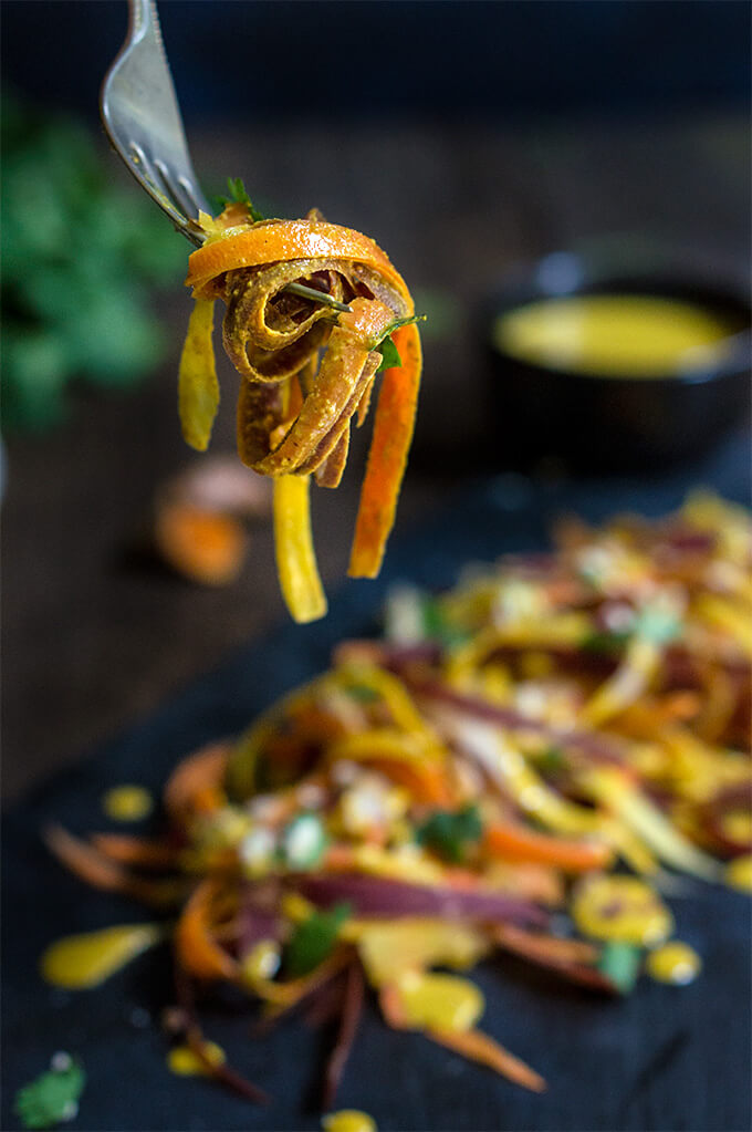 Carrot almond salad - ribbons of rainbow carrots, doused in creamy, turmeric coconut dressing, topped with toasted almonds and fresh cilantro - an explosion of exotic flavors that will surely tantalize your taste buds! | www.viktoriastable.com