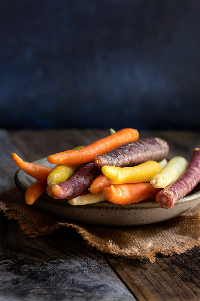 Carrot almond salad - ribbons of rainbow carrots, doused in creamy, turmeric coconut dressing, topped with toasted almonds and fresh cilantro - an explosion of exotic flavors that will surely tantalize your taste buds! | www.viktoriastable.com