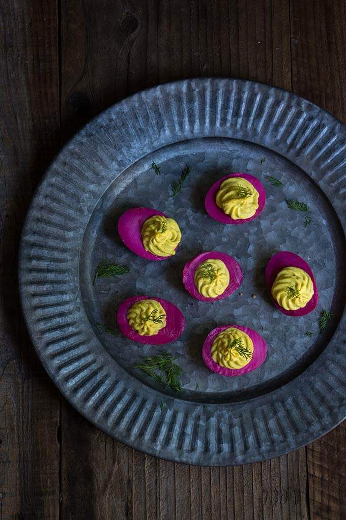Beet-pickled curry deviled eggs - pickled in beet marinade for a gorgeous magenta color, then stuffed with a delicious curry filling, they make a spectacular appetizer, and a great way to utilize those leftover Easter eggs. | www.viktoriastable.com